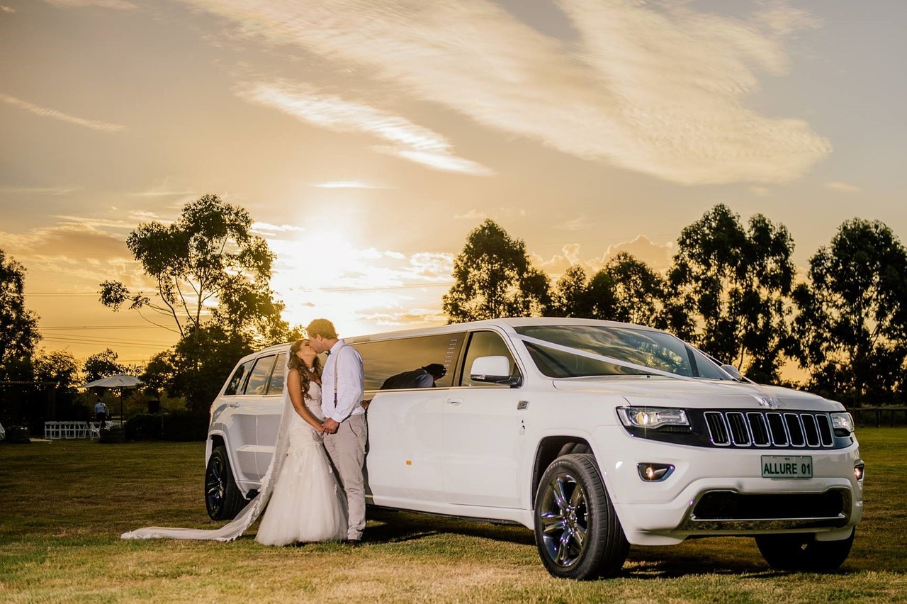 Bride and groom hugging next to their amazing white stretch limo rental with a beautiful sunset in the park Bride and groom hugging next to their amazing white stretch limo rental with a beautiful sunset in the park